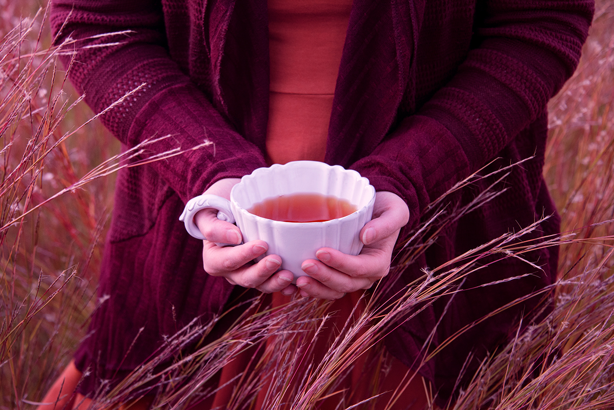 teacup in hands field